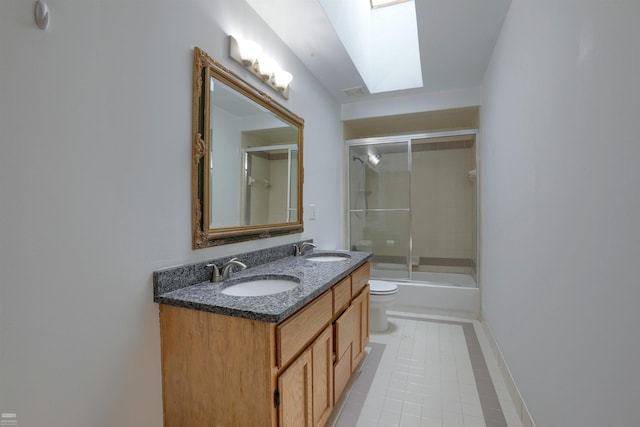 full bathroom featuring toilet, a skylight, shower / bath combination with glass door, tile floors, and double sink vanity