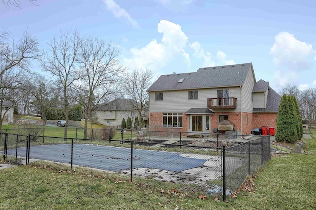 rear view of house with a covered pool, a patio, a balcony, and a yard