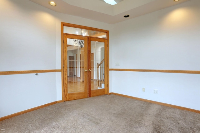 spare room featuring carpet and french doors