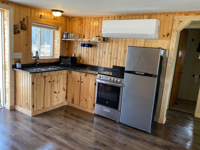 kitchen with light brown cabinets, a wall mounted AC, appliances with stainless steel finishes, and dark hardwood / wood-style floors