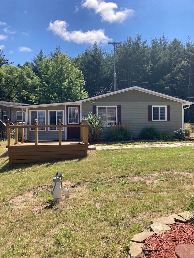 view of front of home featuring a front lawn and a deck