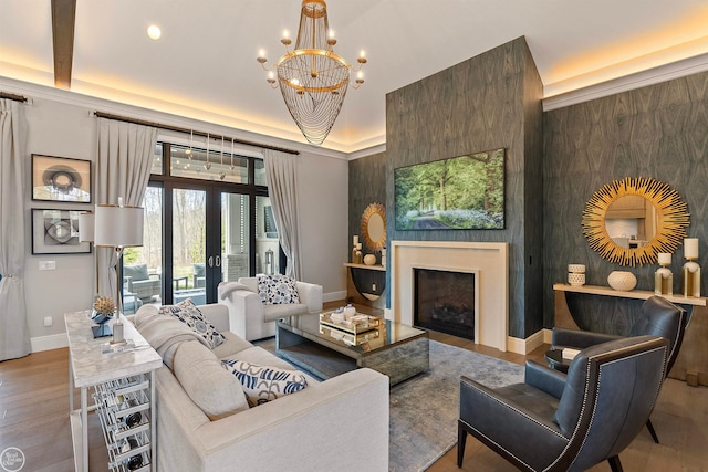 living room featuring a chandelier, hardwood / wood-style flooring, french doors, and a fireplace