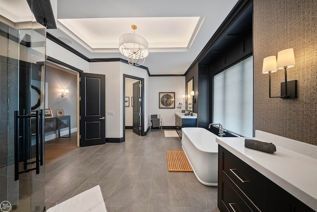 bathroom with tile flooring, a tray ceiling, a bath to relax in, and ornamental molding