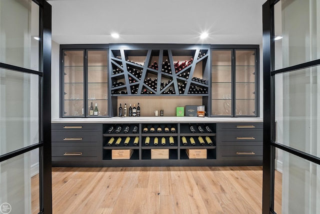 wine cellar featuring light hardwood / wood-style floors and bar area