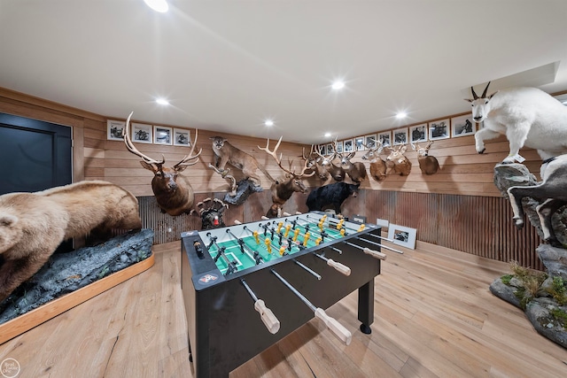 playroom with wood walls and light hardwood / wood-style floors