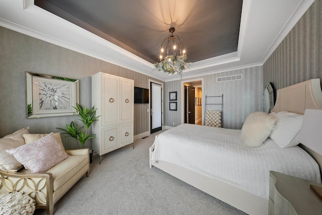 carpeted bedroom featuring a chandelier and a tray ceiling