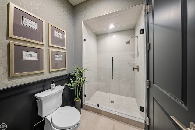 bathroom with tile floors, a shower with shower door, and toilet