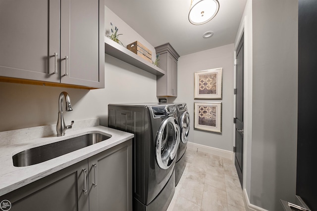 washroom featuring sink, washer and clothes dryer, cabinets, and light tile floors