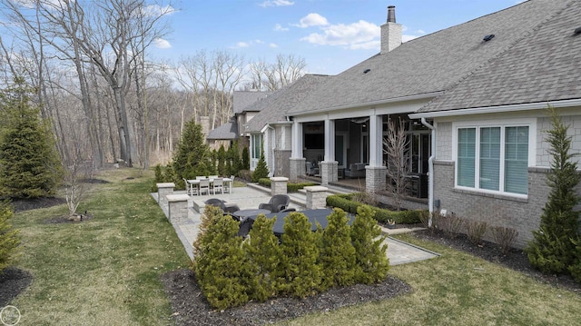 back of house featuring a lawn and a patio area