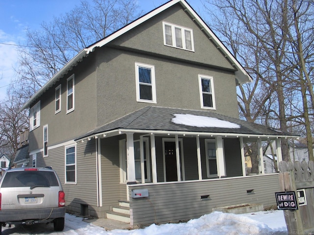 view of front of house featuring stucco siding, a porch, and a shingled roof