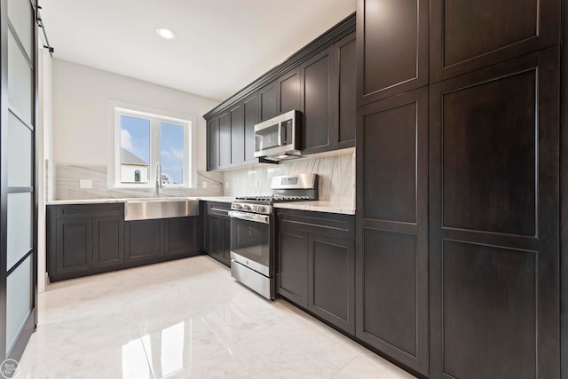 kitchen featuring sink, tasteful backsplash, stainless steel appliances, and light tile flooring