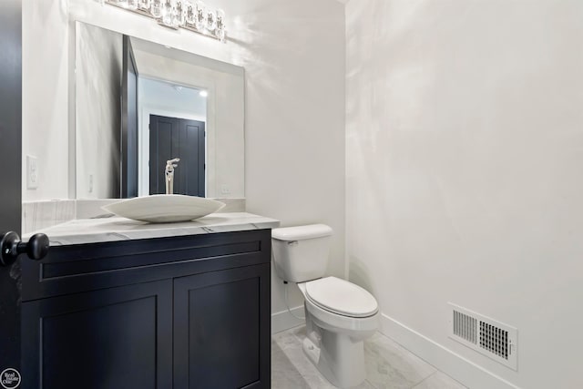 bathroom with vanity, tile floors, and toilet