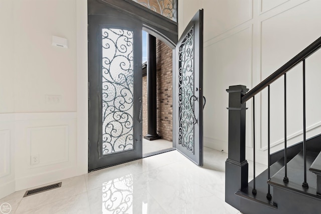 entrance foyer with brick wall and light tile flooring