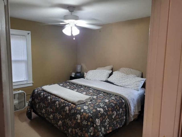 bedroom with dark colored carpet and ceiling fan