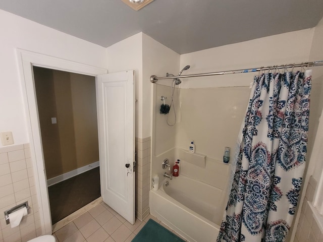 bathroom featuring tile walls, tile floors, and shower / tub combo with curtain