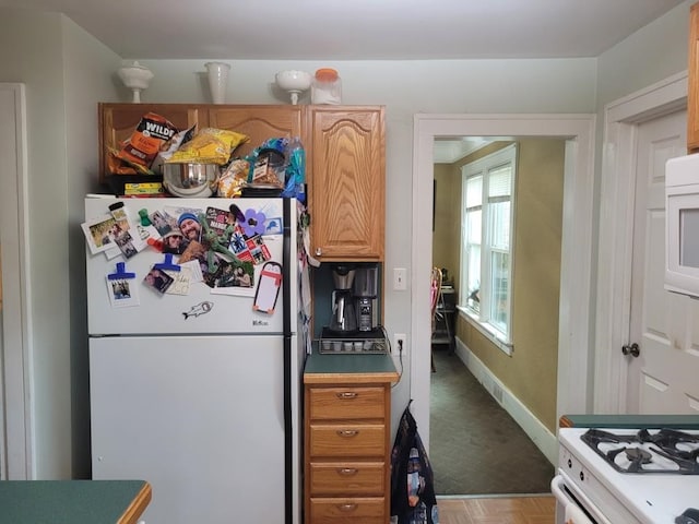 kitchen featuring white appliances and carpet floors