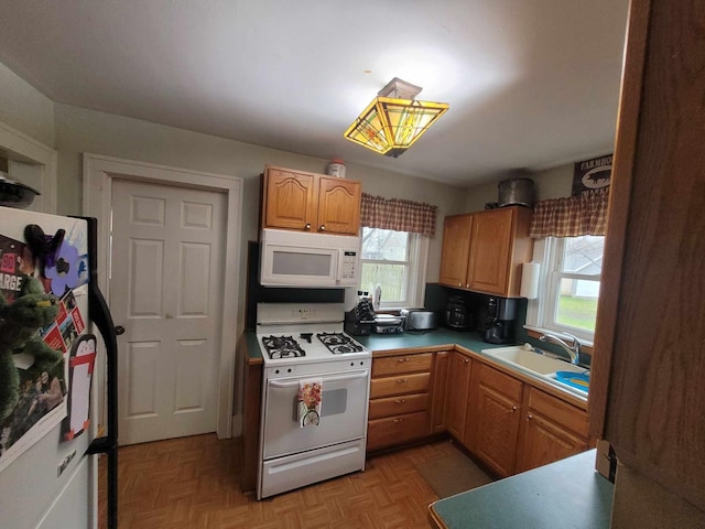 kitchen featuring light parquet floors, white appliances, and sink