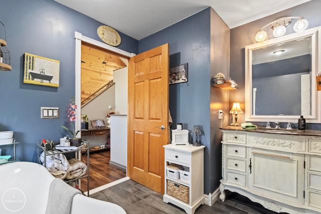 bathroom with hardwood / wood-style flooring, a bathtub, and vanity with extensive cabinet space