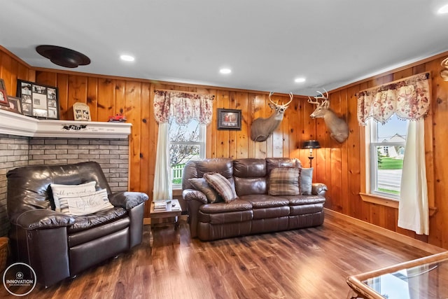 living room featuring wooden walls, a fireplace, and dark hardwood / wood-style floors