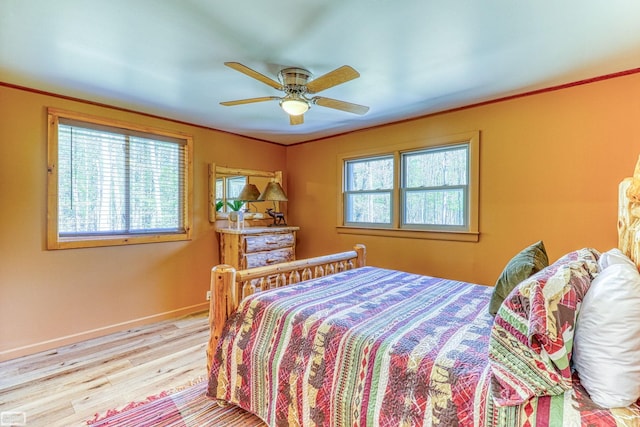 bedroom featuring multiple windows, ceiling fan, and hardwood / wood-style flooring