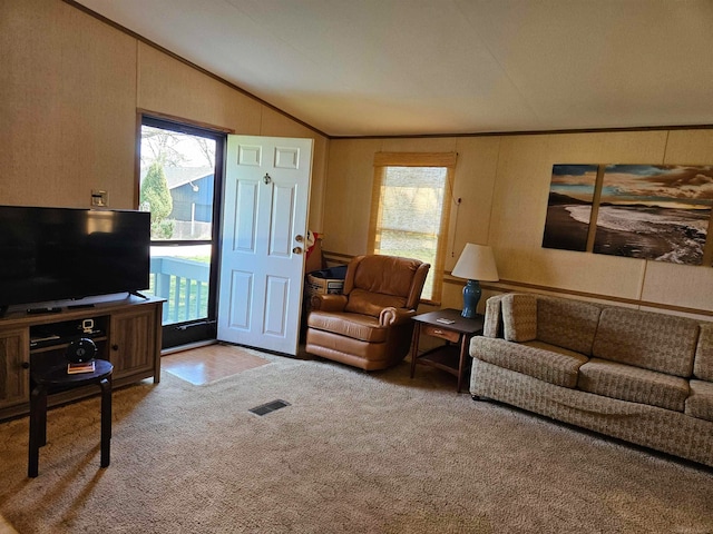 carpeted living room featuring a wealth of natural light and lofted ceiling