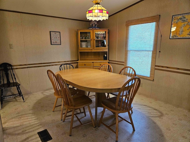 dining room featuring ornamental molding and light tile flooring