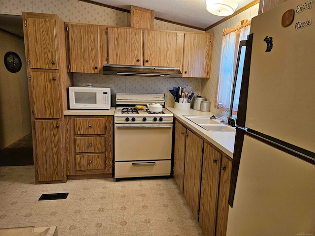 kitchen featuring sink, white appliances, light tile flooring, lofted ceiling, and ornamental molding