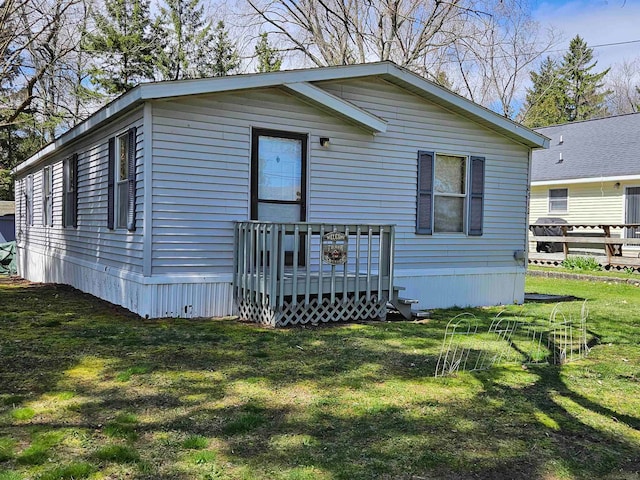 back of property with a yard and a wooden deck