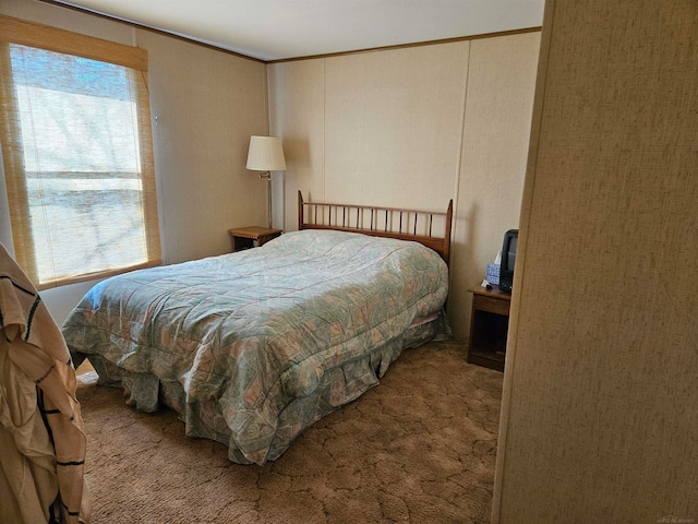 bedroom with carpet floors, ornamental molding, and multiple windows