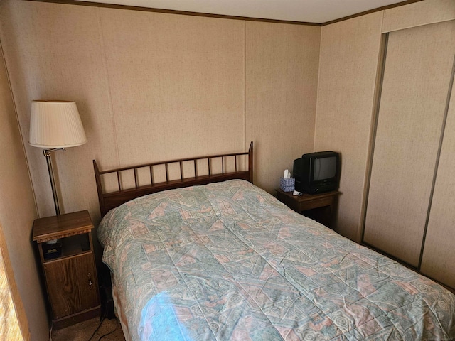 bedroom with a closet and crown molding