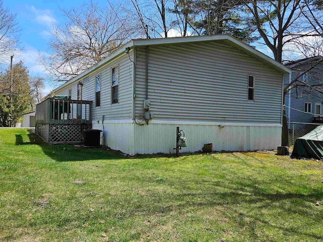 view of home's exterior featuring central AC unit and a yard