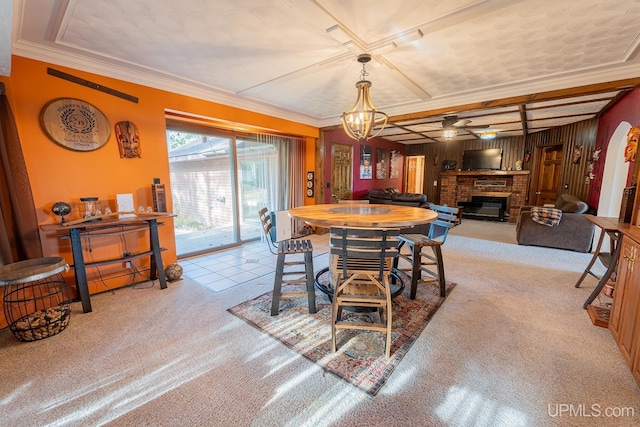 carpeted dining area with crown molding, a fireplace, and wood walls