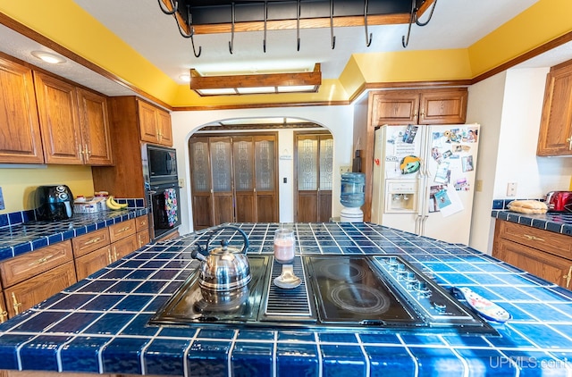 kitchen featuring tile countertops, black appliances, and a center island