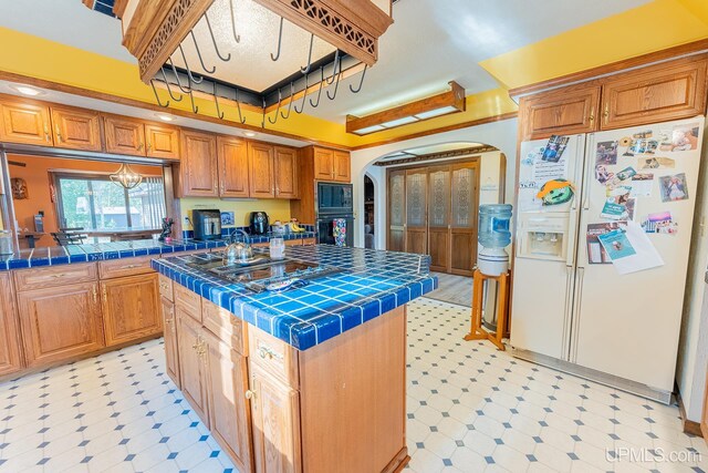 kitchen with a center island, tile countertops, and black appliances