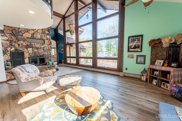 living room with a fireplace, beam ceiling, plenty of natural light, and high vaulted ceiling