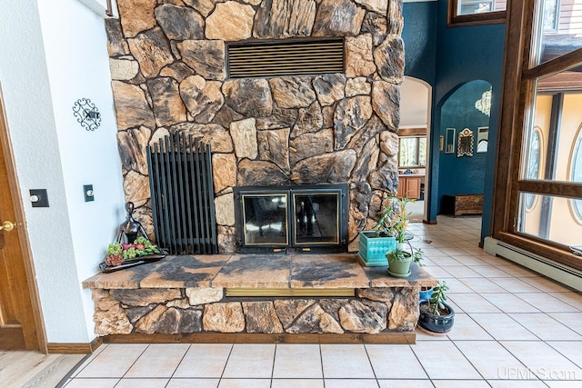 room details with a baseboard radiator and a stone fireplace