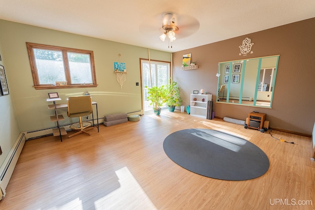 interior space with hardwood / wood-style floors, a healthy amount of sunlight, and a baseboard heating unit