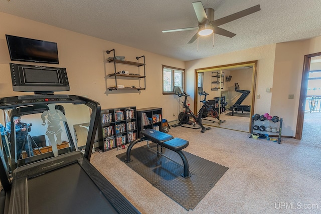 workout area featuring ceiling fan, carpet flooring, and a textured ceiling