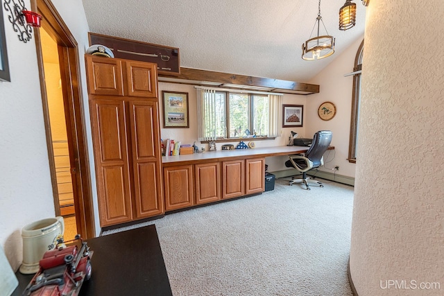 carpeted office space featuring lofted ceiling, built in desk, and a textured ceiling