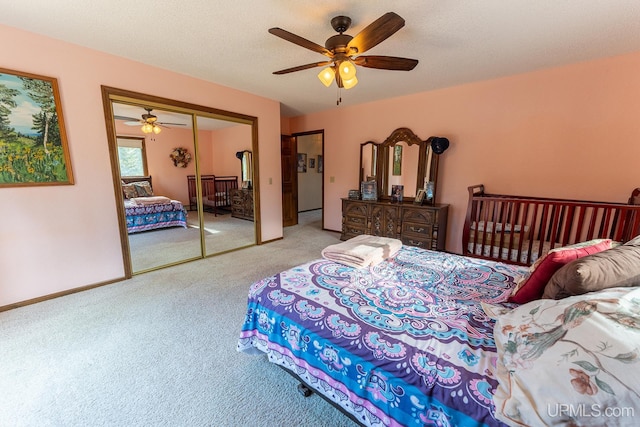 bedroom featuring light carpet, a textured ceiling, and ceiling fan