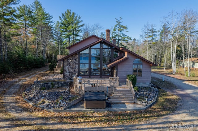 view of front of home with a wooden deck and a sunroom