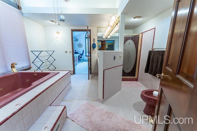 bathroom with a relaxing tiled tub, toilet, and tile patterned flooring