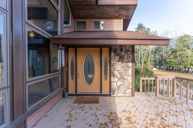 view of exterior entry featuring a wooden deck