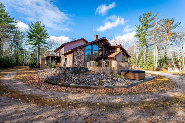 view of property exterior featuring a hot tub and a deck