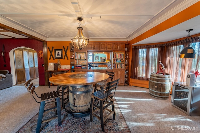 dining space featuring crown molding, a chandelier, and carpet