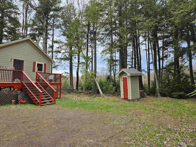 view of yard with a wooden deck and a storage unit