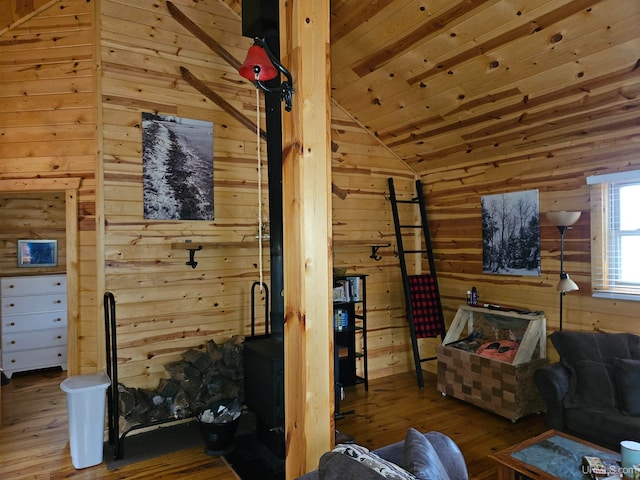 living room with wood-type flooring, wood walls, and vaulted ceiling