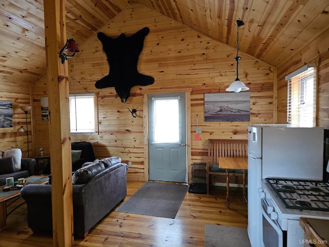 kitchen featuring wood walls, light hardwood / wood-style flooring, fridge, wooden ceiling, and pendant lighting