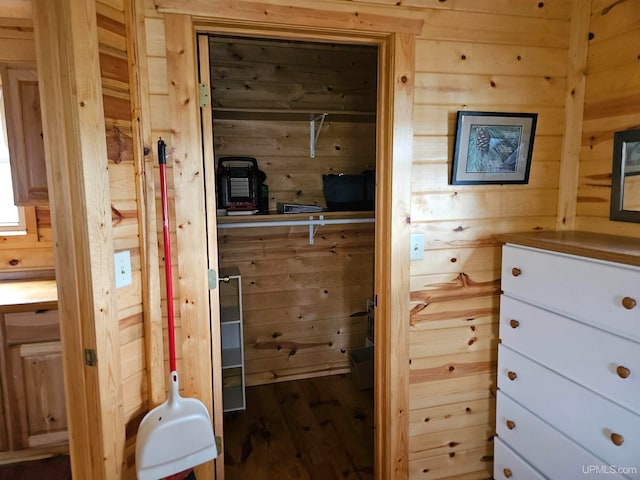 interior space with hardwood / wood-style floors and wooden walls