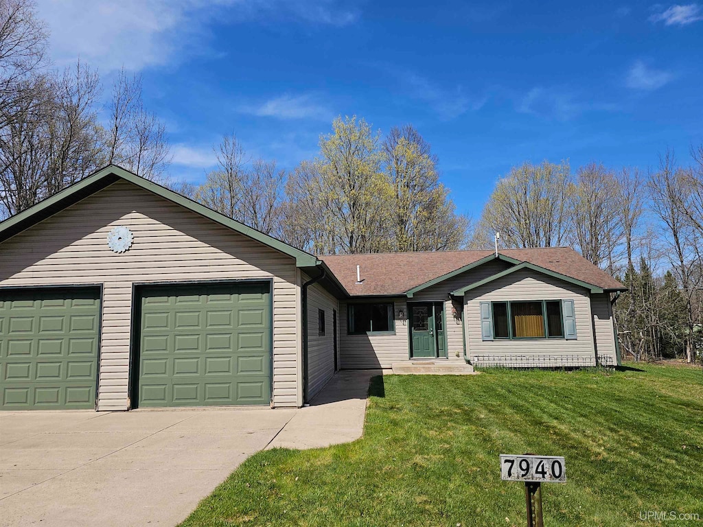 single story home featuring a garage and a front lawn